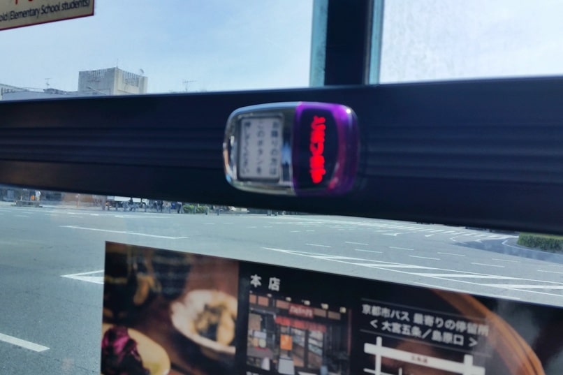 Getting around Kyoto by bus. how to take kyoto bus. button for next stop. Backpacking Japan travel blog